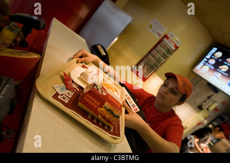 Ein KFC-Mitarbeiter dienen einen hungrigen Kunden im Restaurant auf der Londoner Oxford Street Stockfoto