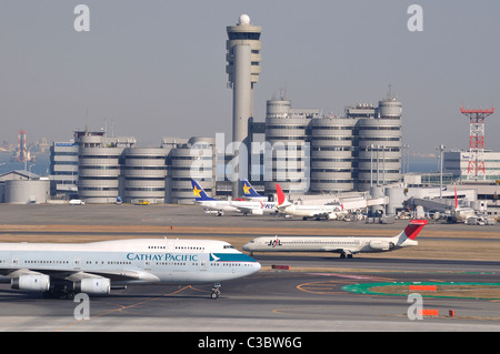 Flugzeug / Flugzeugen auf dem Rollfeld mit Turm im Hintergrund am "Haneda" Tokyo International Airport (Japan) Stockfoto