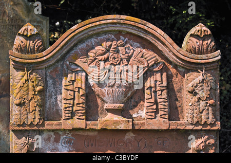 Detail der Grabstein mit drapierten Urn, Rosen und Eichenlaub Design. Kirche von Saint Kentigern. Caldbeck, Cumbria, England, Großbritannien Stockfoto