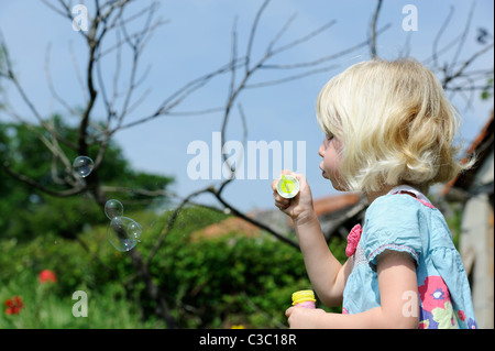 Stock Foto von einem fünf Jahre alten Mädchen bläst Seifenblasen. Stockfoto