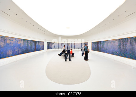 Touristen sehen die Wasserlillies von Claude Monet in der Orangerie Galerie, Tuilerien Garten, Paris Stockfoto