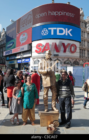 A Street-Artist, gekleidet wie ein Gold plattiert Elvis Presley Unterhaltung Besucher nach London Piccadilly Circus, UK. Stockfoto