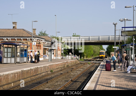 First Great Western Zug sich nähernden Bahnhof mit Passagiere warten auf die Plattform. Nord-Camp, Hampshire, England, Vereinigtes Königreich. Stockfoto