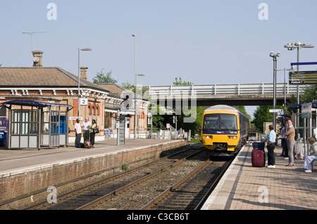 Nord-Camp, Hampshire, England, Vereinigtes Königreich. First Great Western Zug sich nähernden Bahnhof mit Passagiere warten auf Plattform Stockfoto