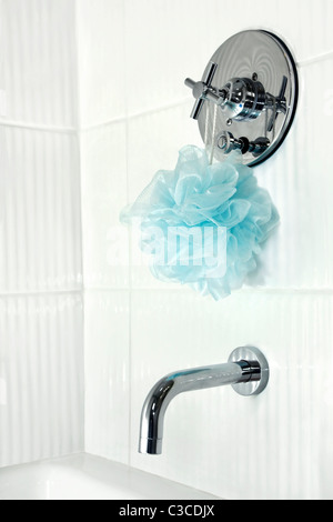 Modern renoviertes Bad mit Wellpappe glänzend weißen Fliesen rund um die Badewanne Dusche, Chrom Wasserhahn und blauen Blätterteig. Stockfoto