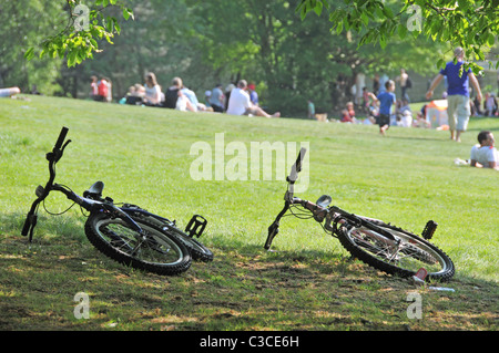 zwei Fahrräder in Hampstead Heath Menschen genießen Feiertag Sonnenschein Familien Kinder Kinder Mütter Väter Stockfoto