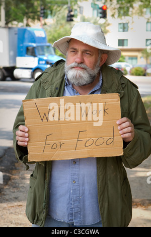 Obdachlose Veteranen betteln an der Seite der Straße mit einem Schild, das sagt, "Will Arbeit für Lebensmittel." Stockfoto