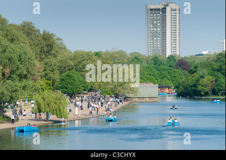 Die Serpentine Lake im Hyde Park, mit dem Hilton Hotel im Hintergrund. London, England, Vereinigtes Königreich. Stockfoto