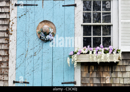 Malerische Cape Cod Scheune mit blühenden Blumenkasten und geschmückten Strohhut an Tür. USA Stockfoto