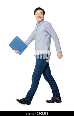 Ein junger Mann zu Fuß mit einem Ordner in der hand Stockfoto
