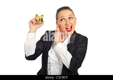 Coolen Business-Frau, die versucht, das Sparschwein sound isoliert auf weißem Hintergrund zu hören Stockfoto