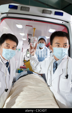 Bewegt ein Patient von einem Krankenwagen Sanitäter Stockfoto