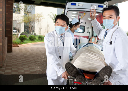 Bewegt ein Patient von einem Krankenwagen Sanitäter Stockfoto