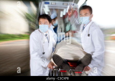 Bewegt ein Patient von einer Ambulanz, Bewegungsunschärfe Sanitäter Stockfoto