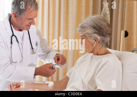 Arzt einen Tropf am Arm seines Patienten zu setzen Stockfoto