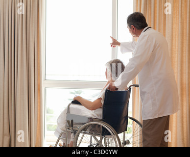 Arzt mit seinem Patienten schaut aus dem Fenster Stockfoto