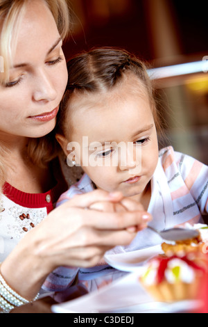 Porträt von netten Mädchen im Café Cupcake mit ihrer Mutter in der Nähe von Essen Stockfoto