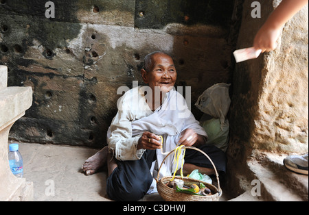 Alte Dame betteln in einem Tempel in Siem Reap, Kambodscha Stockfoto