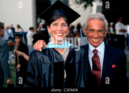 Eine Frau mittleren Alters in einer Mütze und Mantel Posen mit einem Verwandten nach einen Abschluss an der Florida Atlantic University in Fort Lauderdale, Florida, USA. Stockfoto