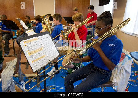 Männliche und weibliche Schülerinnen und Schüler Noten lesen und spielen Posaunen während der Band-Praxis in der Band Hall in Waco Texas. Stockfoto