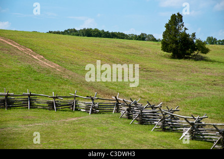 Split Zaun läuft entlang der Unterseite des Hügels hinter der historischen Steinhaus auf dem Manassas nationale Schlachtfeld. Stockfoto