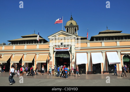 Blauer Himmelsblick der Passanten vor dem rosa Mauerwerk Fassade Haupteingang des Mercado Central, Santiago, Chile Stockfoto