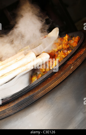Chicken Fajitas sizzling auf Eisen Platte in Küche Stockfoto