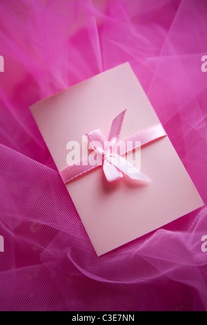 Rosa Karton mit satin-Schleife auf Textil-Hintergrund Stockfoto