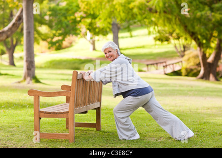 Ältere Frau tut ihr erstreckt sich im park Stockfoto