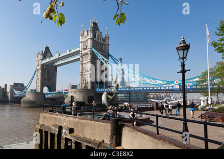 Mädchen mit einem Delfin von David Wynne & Tower Bridge, St Katherine's Dock, London, UK. Stockfoto