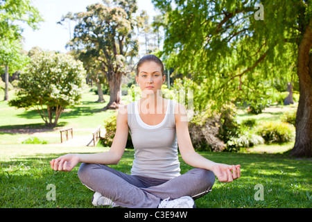 Junge Frau praktizieren Yoga im park Stockfoto