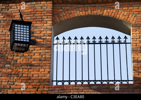 Alte Spitze Zaun und Laterne auf einer gemauerten Wand architektonische details Stockfoto