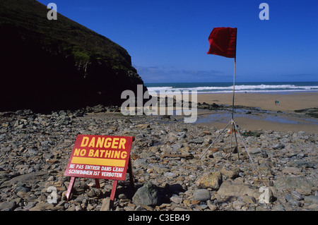 zweisprachige Gefahr keine Warnzeichen Baden und rote Fahne am Kapelle Porth Strand Cornwall uk Stockfoto