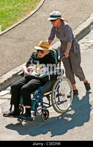 Frau drängen ältere Frau im Rollstuhl - Frankreich. Stockfoto