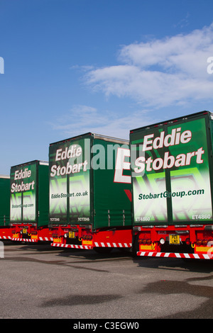 Zeile der geparkten Eddie Stobart Lkw Anhänger und Container Lkw Halt Reihe von LIVREE AEC Scania 440 Spedition Fahrzeuge. Stockfoto