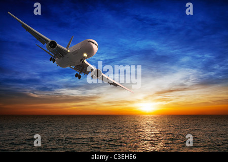 Nachtflug. Jet-Flugzeuge über dem Meer in der Abenddämmerung. Stockfoto