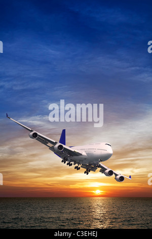 Jet-Liner über dem Meer bei Sonnenuntergang Stockfoto
