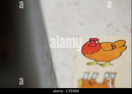 Childs Huhn domino Holzspielzeug auf einer Fensterbank abstrakt. Flache DOF Stockfoto