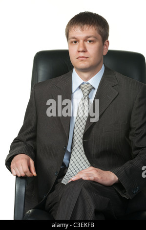 Der junge Geschäftsmann in einem Sessel. Es ist isoliert auf weißem Hintergrund Stockfoto