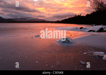 Winter-Sonnenuntergang am Loch Morlich, Aviemore, Schottland, Vereinigtes Königreich Stockfoto