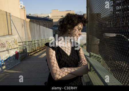 Junge Frau bedeckt mit Schatten Muster, Brooklyn, New York. Stockfoto