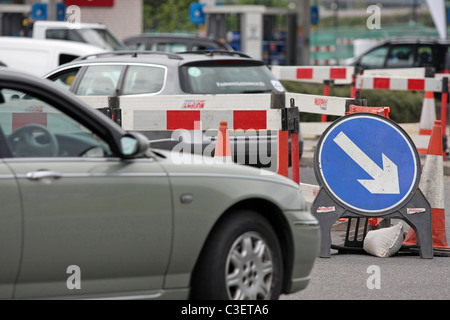 Fahrzeugen, Wegweiser und Sicherheitsbarrieren um Baumaßnahmen in London, England Stockfoto