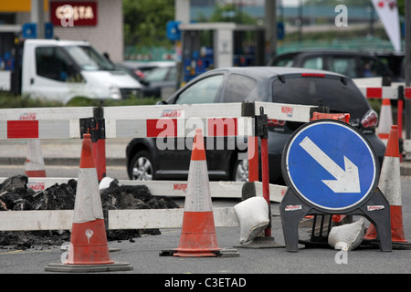 Fahrzeugen, Wegweiser und Sicherheitsbarrieren um Baumaßnahmen in London, England Stockfoto