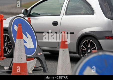 Fahrzeugen, Wegweiser und Zapfen in Baustellen in London, England Stockfoto