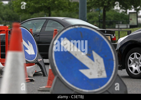 Fahrzeugen, Wegweiser und Zapfen in Baustellen in London, England Stockfoto