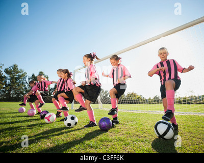 Mädchen-Fußball-Spieler in der Nähe von Net üben Stockfoto