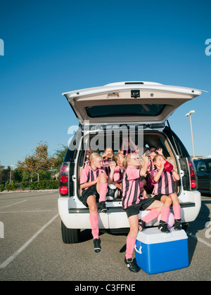 Mädchen-Fußball-Spieler sitzen auf der Rückseite Auto Stockfoto