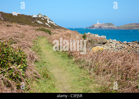 Küstenweg auf der Insel Tresco in Scilly-Inseln in der Nähe von Gimble Porth mit Round Island Ighthouse über das Wasser Stockfoto