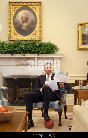 Präsident Barack Obama ruht seinen Fuß auf einen Fußball der Ratstagung inländische Politik im Oval Office Washington Stockfoto