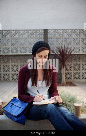 Kaukasische Frau schreiben in Journal Natur Stockfoto
